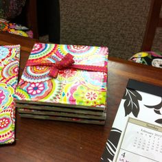 a table topped with notebooks covered in brightly colored paper and a calendar on top of it