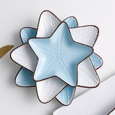 a blue and white star brooch sitting on top of a table next to scissors