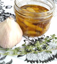 a jar filled with pickled vegetables next to an onion and garlic on a table