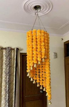 a chandelier made out of yellow flowers hanging from the ceiling in a living room