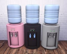 three water dispensers sitting next to each other on top of a wooden floor