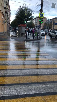 people crossing the street at an intersection on a rainy day