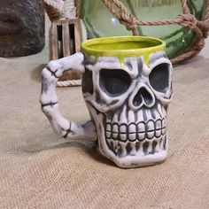 a white and yellow skull mug sitting on top of a table