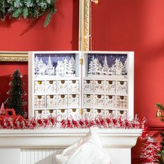 a fireplace with christmas decorations on the mantle and in front of it is a red wall