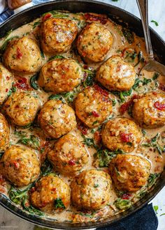 a skillet filled with meatballs covered in gravy and garnished with herbs