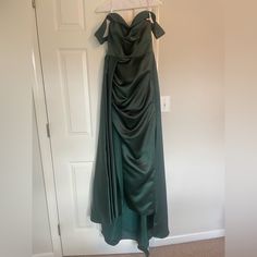 a green dress hanging on a white door