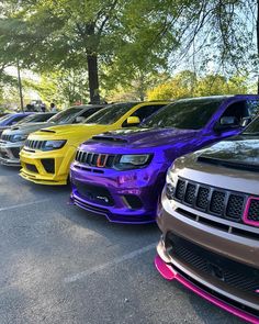 a row of different colored cars parked next to each other