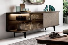 a living room with a table, mirror and vases on the sideboard in front of it