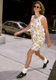 a woman walking down the street with her foot in the air