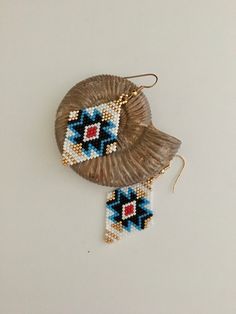 A lovely pair of Southwestern style earrings hand beaded with Delica seed beads. Delica seed beads are very uniform and give wonderful detail to this beautiful pair of handcrafted earrings. Bright colors of gold, blues, red and white combine for a truly awesome pair of Native American style earrings. Hand beaded with strong nylon thread they are lightweight and very comfortable to wear these would look awesome with that jeans outfit! Gold plated ear wires complete the design. Overall length is 2 1/2" Drop length is 1 7/8" Width is 1 1/4" Colors may vary depending on computer monitor. Photos are enlarged to show detail. Questions or need more photos? Just message us prior to purchasing. Please read all policies below and on the home page and message us with all questions propr to purchasing Southwestern Style Earrings With Tiny Beads For Gift, Southwestern Style Small Beaded Earrings For Gift, Southwestern Handwoven Beaded Earrings For Gift, Beaded Earrings Brick Stitch, Beaded Earrings Native American, Earring Inspo, Jewelry 2023, Earrings Native American, Stitch Earrings