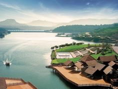 an aerial view of a resort on the edge of a body of water with mountains in the background