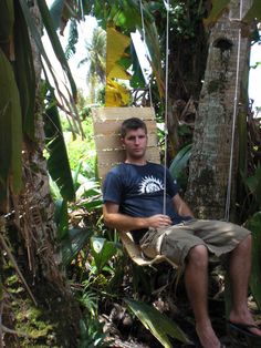 a man sitting on a chair in the jungle