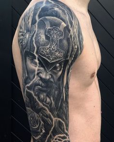 a man's half sleeve with an image of a viking warrior on his shoulder