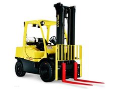 a yellow forklift sitting on top of a white floor next to a red object