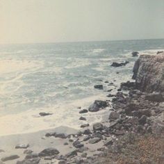 an old photo of the ocean and rocks