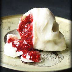 a piece of cake with white frosting and raspberry sauce on it sitting on a plate