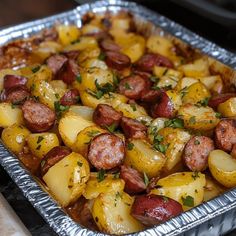 a metal pan filled with potatoes and sausage