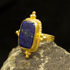 Ancient Art Lapis Lazuli Ring | 24K Gold Plated | Tree Bark Silver Ring | 925 Sterling Silver | Dainty Ring | Vintage Gift by Pellada Our shop offer free ring sizing Handcrafted Tree Bark Ring Metal : 925 Sterling Silver Plating : 24K Gold Band Width : 4 mm Gem Stone : Lapis Lazuli Gem Color : Navy Blue Gem Size : 18 X 14 mm Ring Size : 30X 25 mm Ring Weight : 9.3 grams Ring Size : US 6 (The size you want is made for free). (We used the US standard sizing) **Custom Orders is Made** As pellada fa Unique Gold Sapphire Ring As A Gift, Handmade Luxury Gold Sapphire Ring, Rectangular Gold Sapphire Ring Gift, Rectangular Sapphire Ring In Gold Setting, Unique Handmade Gold Sapphire Ring, Handmade Gold Sapphire Ring In Sterling Silver, Bark Ring, Red Coral Earrings, Hammered Jewelry