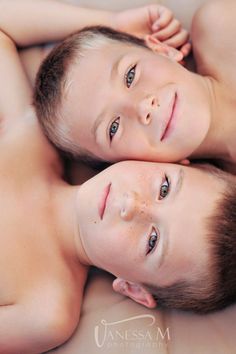 two young boys laying on top of each other