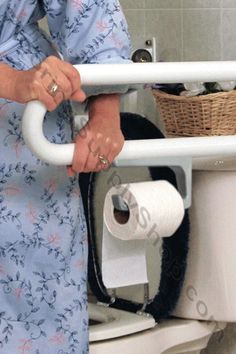 a woman is holding the bars on her toilet