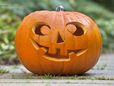 a carved pumpkin sitting in the grass