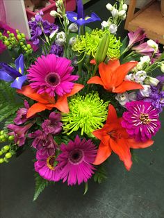 a vase filled with lots of different colored flowers