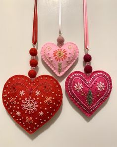 three heart shaped ornaments hanging on a wall