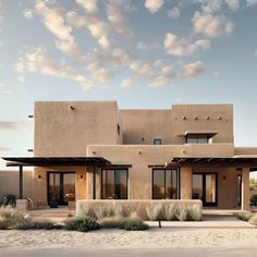 an adobe - style house sits in the desert