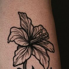 a black and white photo of a flower on someone's leg with the word love written below it