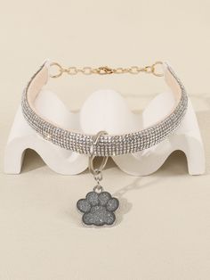 a dog's paw charm is attached to the collar of a choker necklace