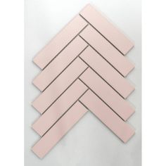 pink tiles arranged in the shape of an arrow on a white surface with grey lines