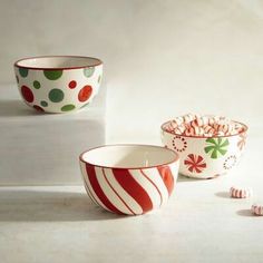 three bowls filled with candy canes on top of a white counter next to each other