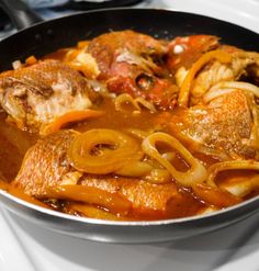 a pan filled with meat and onions on top of a stove