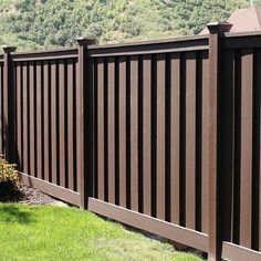 a black fence in front of a green hillside