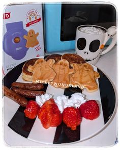 a plate topped with pancakes, strawberries and other breakfast foods next to a microwave