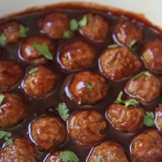 meatballs with sauce and parsley in a white bowl