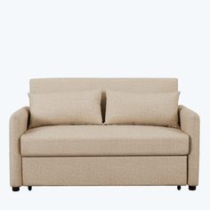 a beige couch with two pillows on it's back and one arm folded up