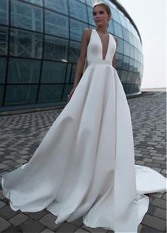 a woman in a white dress is standing outside