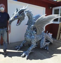 a man standing next to a statue of a dragon