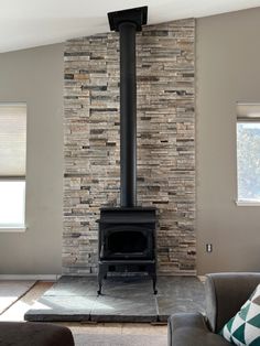 a living room filled with furniture and a fire place in front of a stone wall