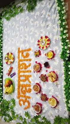 there is a sign that says happy birthday surrounded by flowers and fruit on the table