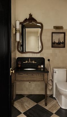 a black and white checkered floor in a bathroom with a sink, toilet and mirror