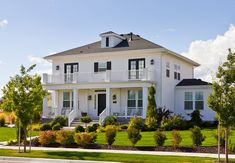 a large white house sitting on the side of a road