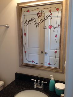 a bathroom sink with a happy birthday sign on the mirror over it's door