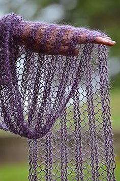 a purple net hanging from the side of a tree