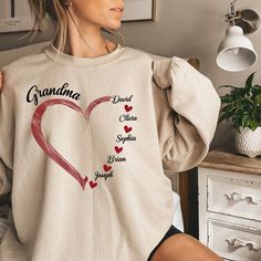 Personalized Grandma Sweatshirt, Grandma Heart Sweat, Christmas Gigi Tee-shirt, Abuela T-shirt, Grandkids Name Shirt, Gift For Grandma, Nana Crewneck, Gigi Shirt, Valentines Gift for Grandma You are welcome to Tabithas Fashion store! I'm here to help you to have a good shopping experience as much as I can. If you have any request (more size and color options) please feel free to message me. I will reply as soon as possible. * Please note: This design will be made with Direct To Fabric print (DTF). * I have listed some information to help you below: - Price is for 1 shirt. 𝑶𝑹𝑫𝑬𝑹𝑰𝑵𝑮 𝑰𝑵𝑭𝑶 1- Please check all the photos from the listing. 2- Please choose your T-shirt, Sweatshirt, or Hoodie size and color. (T-shirt, Sweatshirt, or Hoodie sizes are shown on the listing photos) 3- Ple Mother's Day Crew Neck Top With Heart Graphic, Personalized Long Sleeve T-shirt For Mother's Day, Customizable Crew Neck Tops For Valentine's Day, Long Sleeve T-shirt With Name Print Gift, Casual Tops With Heart Shape And Name Print, Casual Heart-shaped Top With Name Print, Valentine's Day Crew Neck Top With Name Print, Long Sleeve Tops With Heart Graphic For Gift, Heart Graphic Long Sleeve Top As Gift