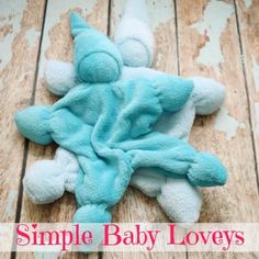 a blue teddy bear laying on top of a wooden floor with the words simple baby loves