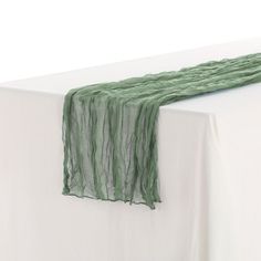 a white table topped with a green scarf