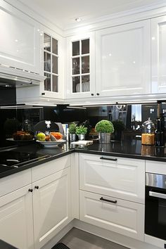 a kitchen with white cabinets and black counter tops