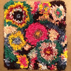 a multicolored crocheted square with flowers on it